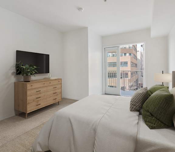 A bedroom with a large bed, a TV on a wooden stand, and a window with a view of a building outside.