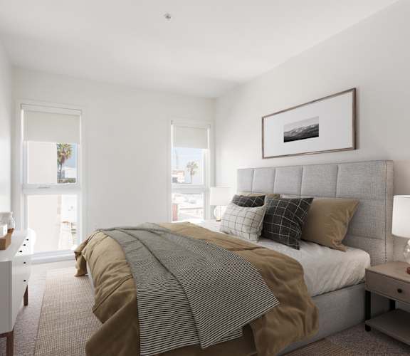 A bedroom with a bed, nightstand, and lamp.