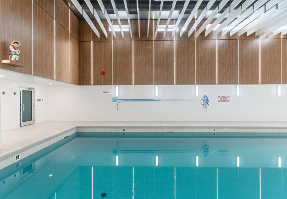a large indoor swimming pool with white walls and wood paneling