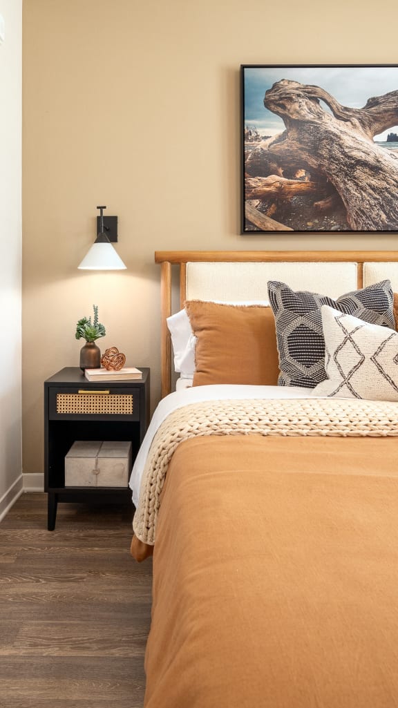 a bedroom with a bed and a night stand with a lamp