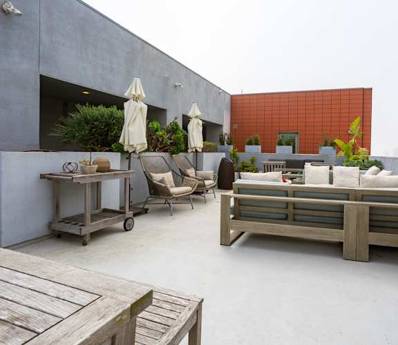A patio with a table, chairs, and a bench.