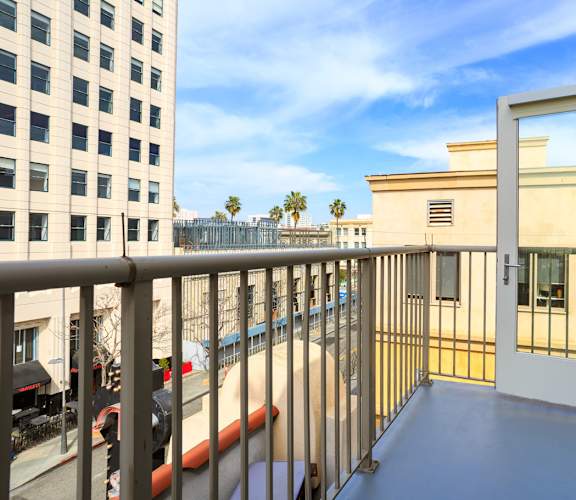 A balcony with a white door and a metal railing.
