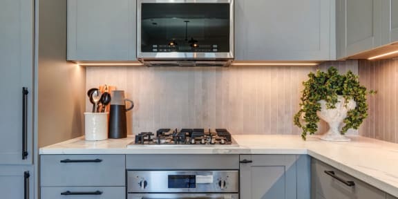 a white kitchen with a stove and a microwave