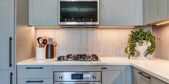 a white kitchen with a stove and a microwave
