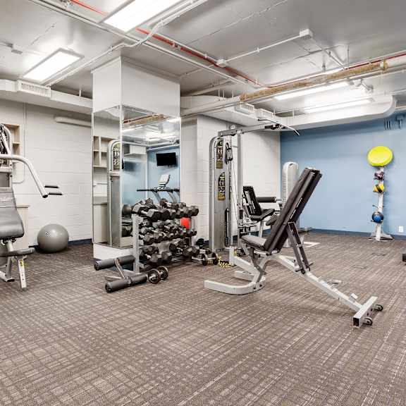  a spacious fitness center with cardio equipment and weights