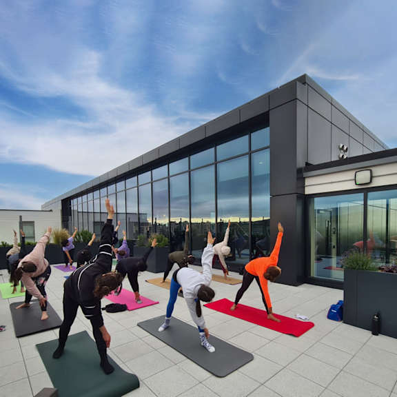 A group of people doing yoga on a rooftop.