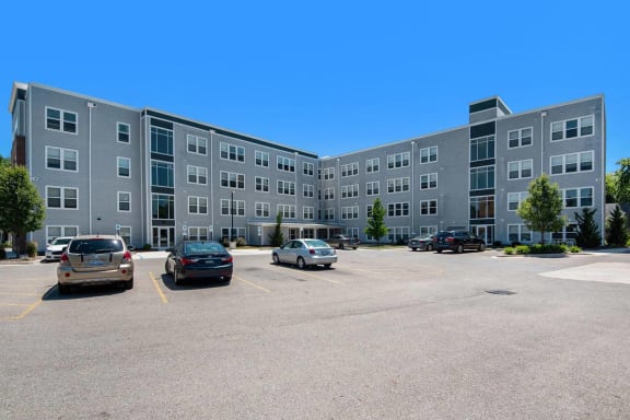 an apartment building in a parking lot with cars