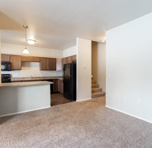 an empty apartment with a kitchen and a staircase