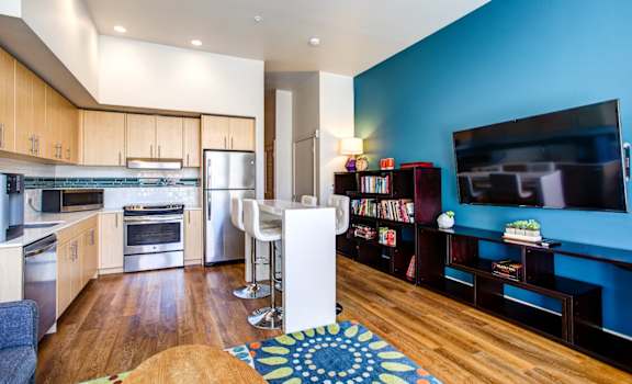 a kitchen and living room with a blue accent wall