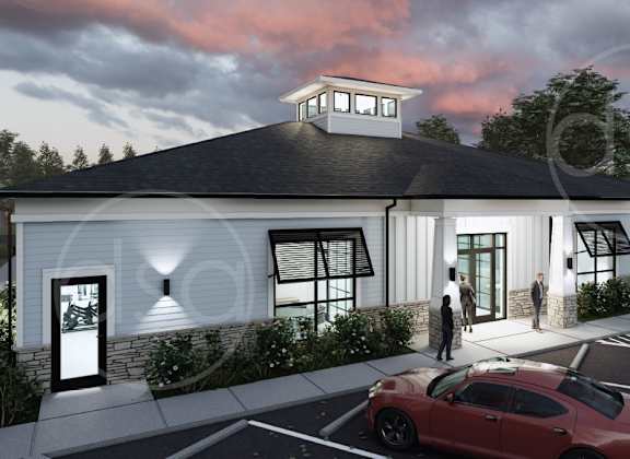 A red car is parked in front of a white building with a black roof.