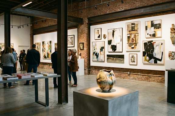 A group of people are looking at artwork on display in a gallery.
