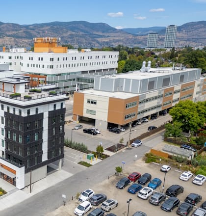 A large, modern building complex with a parking lot in front.