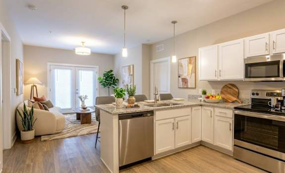 A modern kitchen with white cabinets and stainless steel appliances.