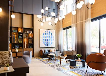 the lobby of a hotel with chairs and couches