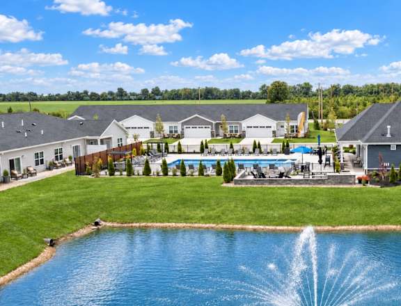 A large house with a pool and a fountain in front.