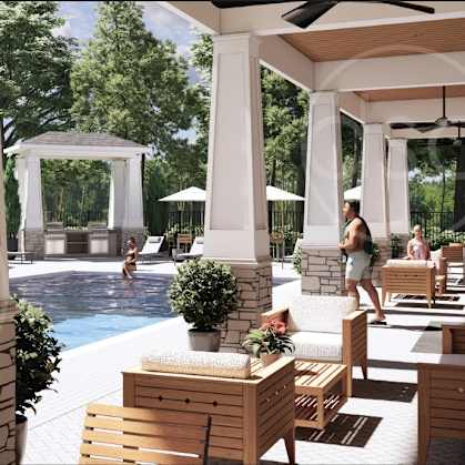 A pool area with a woman walking and several lounge chairs.