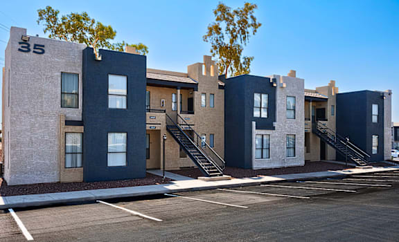 A row of modern houses with dark blue and beige exteriors.