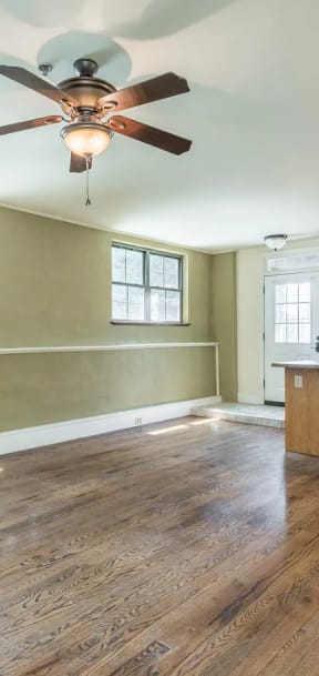 an empty kitchen and living room with a ceiling fan