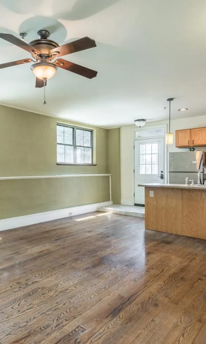 an empty kitchen and living room with a ceiling fan