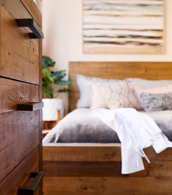 a bedroom with a wooden bed and a painting on the wall