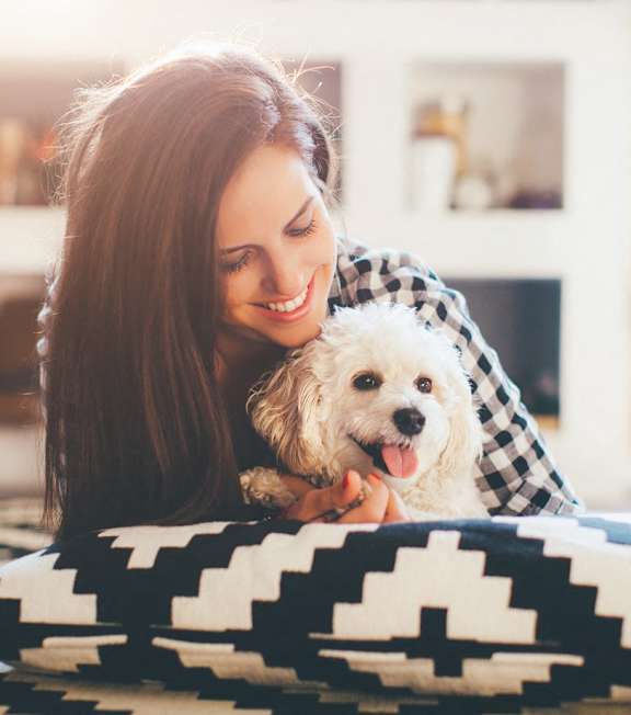 a woman laying on a bed with her dog