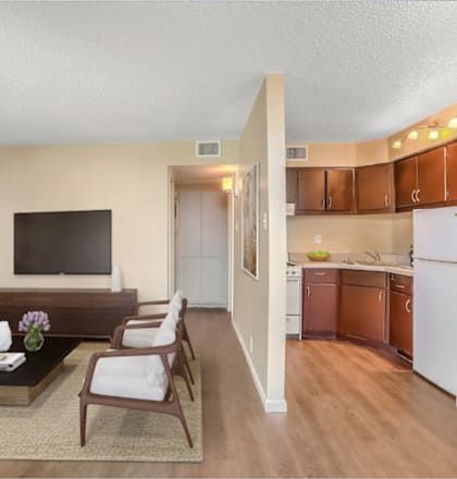 a living room and kitchen with a couch and a table