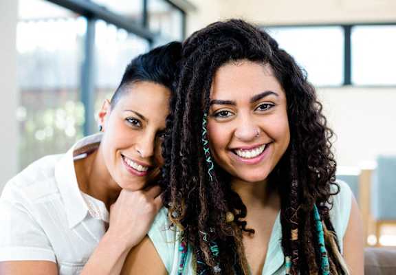 a couple of women are smiling and hugging each other