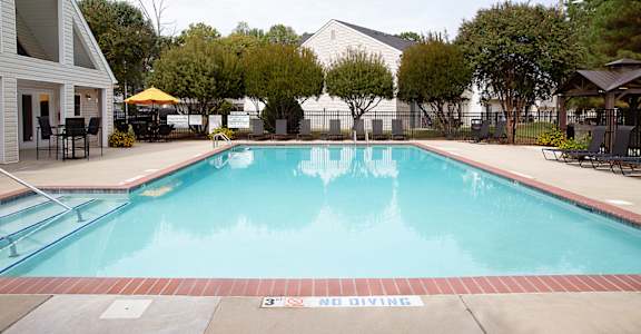 A pool with a diving board and a warning sign.