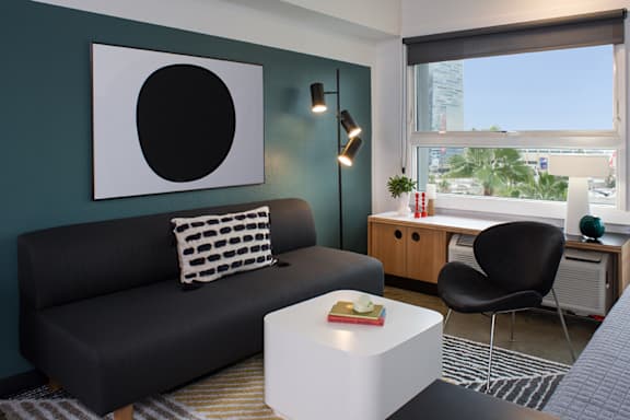 a living room with a black couch and a white coffee table at The Flat in Los Angeles, 90017