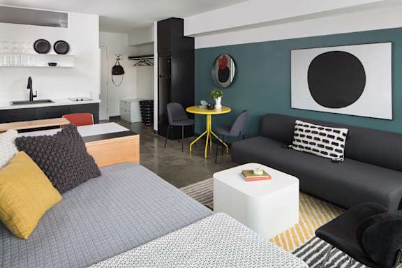 a living room with couches and a table and a kitchen at The Flat in California 90017