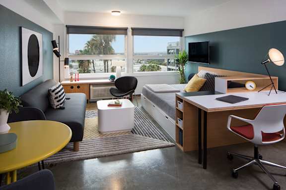 a studio apartment with a bed and a desk and a window at The Flat in CA 90017