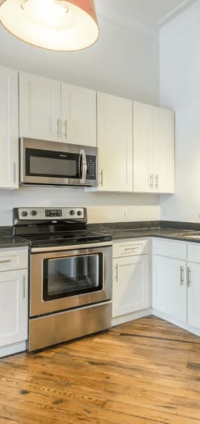 a kitchen with white cabinets and stainless steel appliances