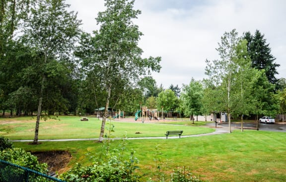 A park with a playground and a white van in the background. at Crown Pointe, Lakewood, WA, 98499