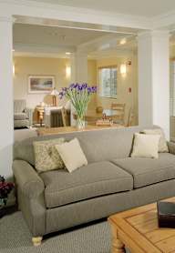 A living room with a grey couch, a wooden coffee table, and a green bowl on it.