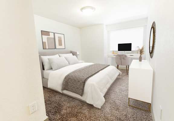 A bedroom with a large bed and a desk with a computer.