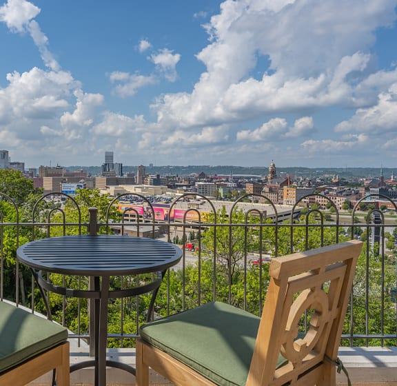 a balcony with two chairs and a table with a view of the city at Adams Edge Apartments, Cincinnati
