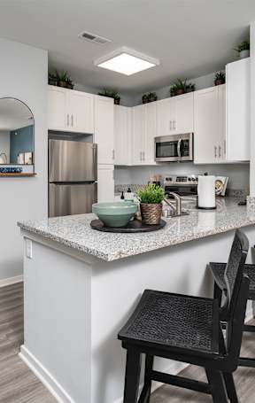 an open kitchen with a granite counter top and stools