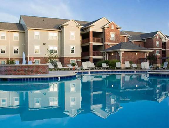 a swimming pool with apartment buildings in the background
