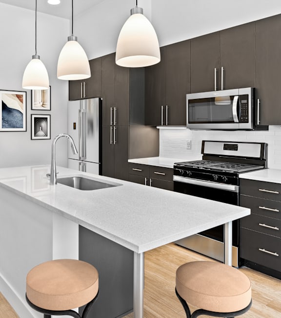 A modern kitchen with a white countertop and black cabinets.