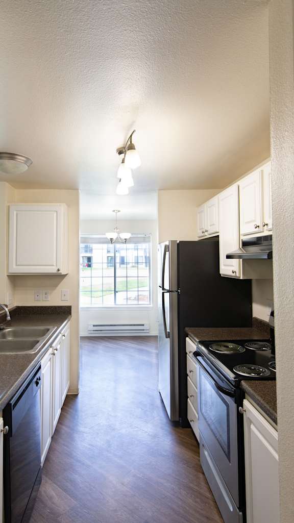 an open kitchen with white cabinets and black appliances