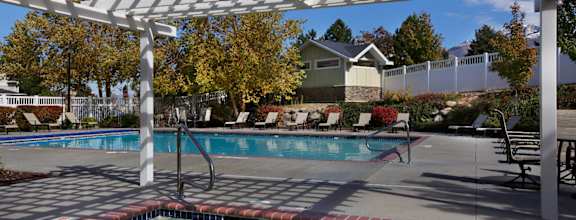 A pool under a white canopy with trees in the background at Liberty Hill Apartments, Draper, UT 84020