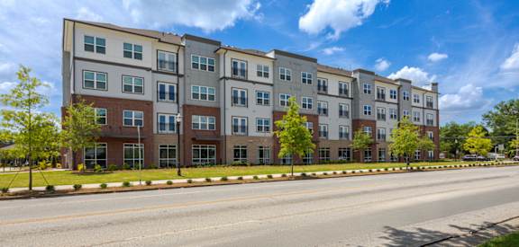 A row of modern apartment buildings with trees in front.