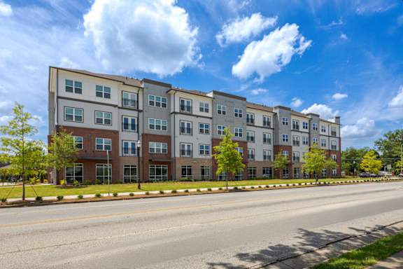A row of modern apartment buildings with trees in front.