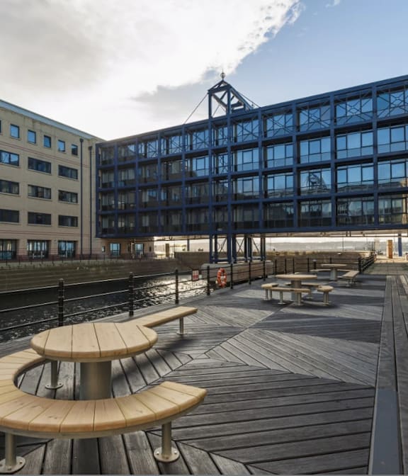 a canal with a boat in front of a large building at The Keel Apartments, Liverpool, L3 4GE