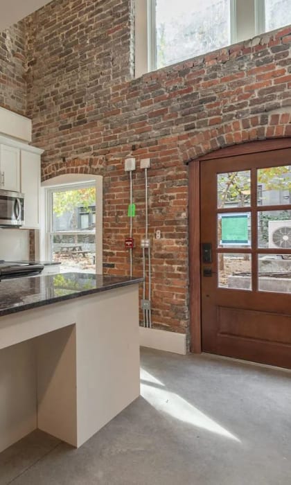 a kitchen with a long counter and a brick wall