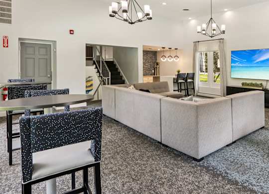 A modern living room with a grey carpet and a white sofa.