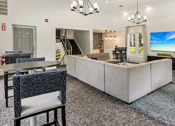 A modern living room with a grey carpet and a white sofa.