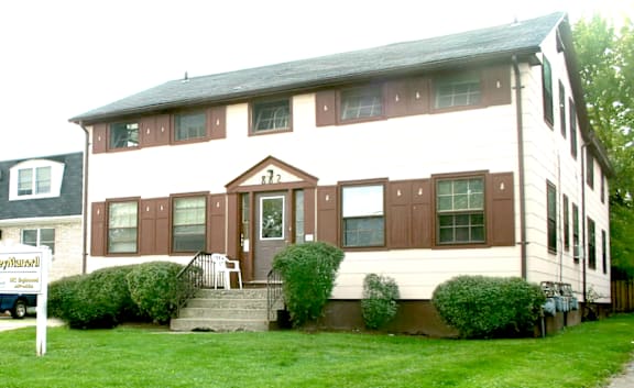 A white house with brown trim and a brown door.