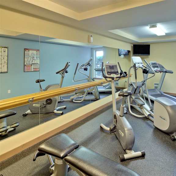 A gym with treadmills, exercise bikes, and elliptical machines.