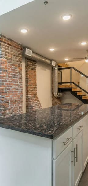 a kitchen with an island and exposed brick walls
